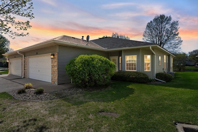 351 100th Ct NE, Blaine, MN 55434 - property exterior at dusk featuring a garage, a yard, concrete driveway, stone siding, and a shingled roof