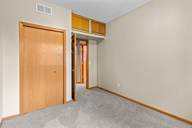 351 100th Ct NE, Blaine, MN 55434 - unfurnished bedroom with light colored carpet, a closet, and a textured ceiling