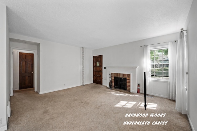 unfurnished living room featuring carpet floors, a brick fireplace, a textured ceiling, and baseboards