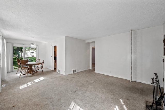 living area with a textured ceiling, carpet flooring, and baseboards