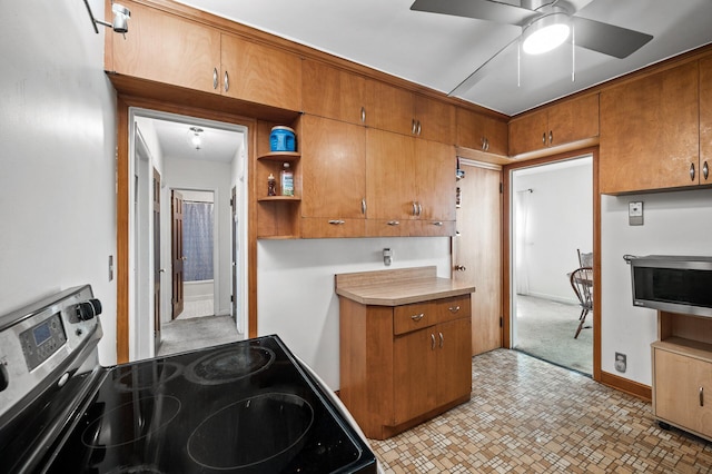 kitchen with appliances with stainless steel finishes, brown cabinets, ceiling fan, light countertops, and open shelves