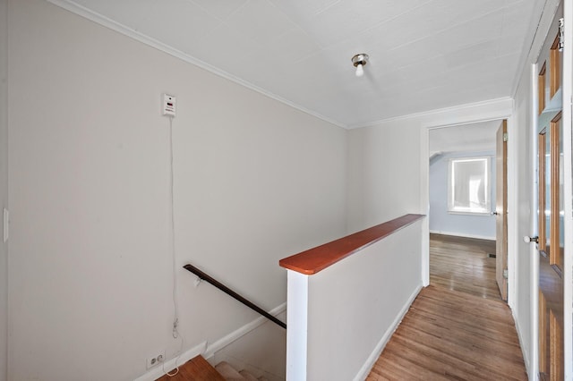 corridor with crown molding, an upstairs landing, wood finished floors, and baseboards