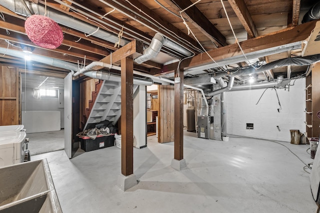 below grade area with heating unit, stairs, and washer and clothes dryer