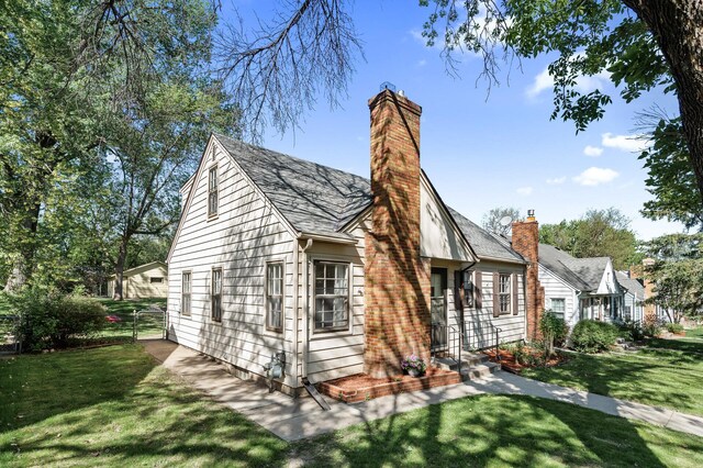 rear view of property featuring a yard and a chimney