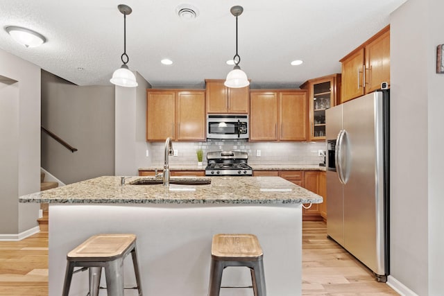 2119 Cedar Grove Trl, Eagan, MN 55122 - kitchen featuring stainless steel appliances, a sink, light wood-style flooring, a breakfast bar, and recessed lighting