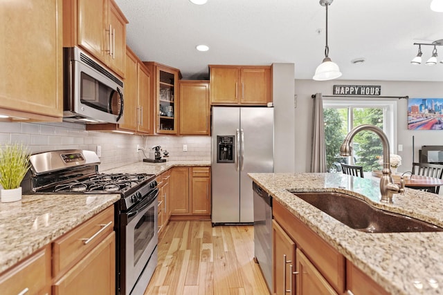 2119 Cedar Grove Trl, Eagan, MN 55122 - kitchen featuring stainless steel appliances, a sink, light wood-style flooring, glass insert cabinets, and backsplash
