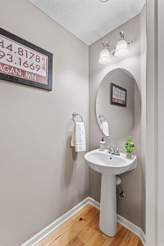 2119 Cedar Grove Trl, Eagan, MN 55122 - bathroom with wood finished floors, baseboards, a textured ceiling, and a sink