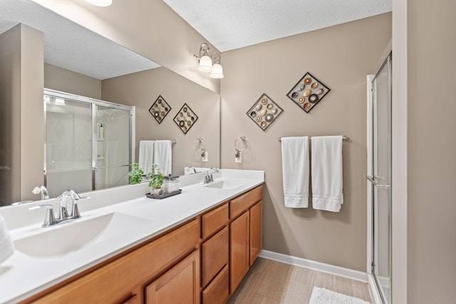 2119 Cedar Grove Trl, Eagan, MN 55122 - full bath featuring a shower stall, double vanity, baseboards, and a textured ceiling