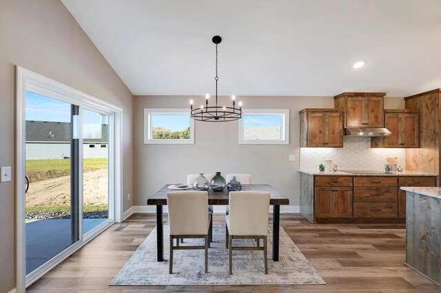 17795 Hoover St NW, Elk River, MN 55330 - dining space featuring a chandelier, light wood-style floors, recessed lighting, baseboards, and lofted ceiling