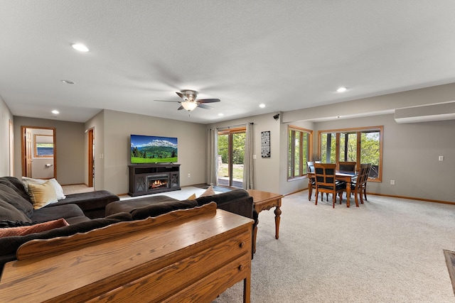 W10415 521st Ave, Prescott, WI 54021 - living room with recessed lighting, light colored carpet, baseboards, a ceiling fan, and a warm lit fireplace