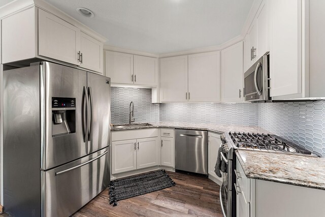 W10415 521st Ave, Prescott, WI 54021 - kitchen featuring stainless steel appliances, a sink, light stone countertops, white cabinets, and dark wood-style floors