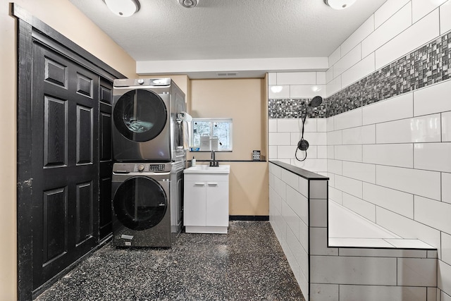W10415 521st Ave, Prescott, WI 54021 - washroom with estacked washer and dryer, a textured ceiling, baseboards, and cabinet space
