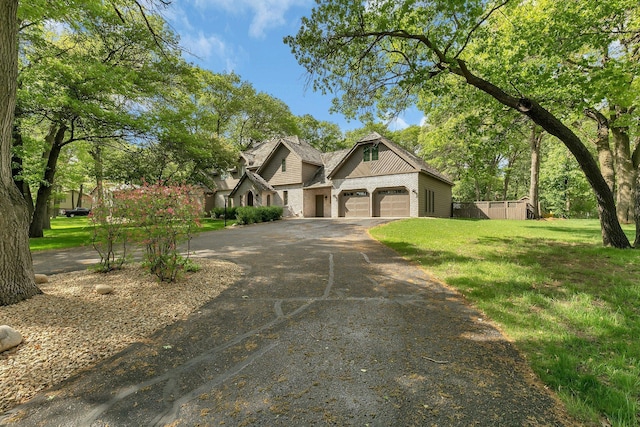 view of front of house featuring driveway, a front lawn, brick siding, and a garage