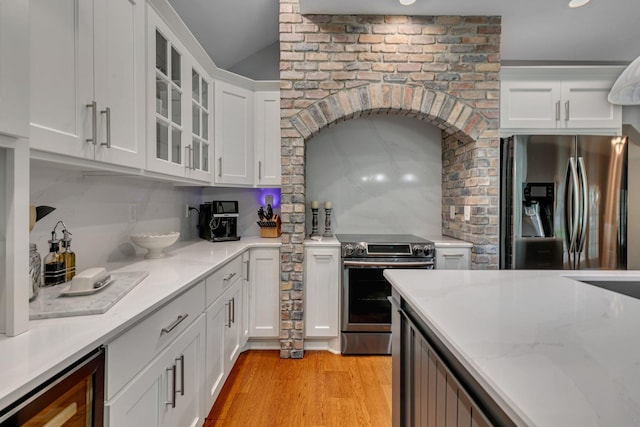 kitchen with stainless steel appliances, decorative backsplash, white cabinets, beverage cooler, and glass insert cabinets