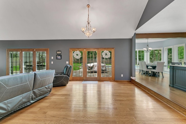 living room with a chandelier, light wood-style floors, and baseboards