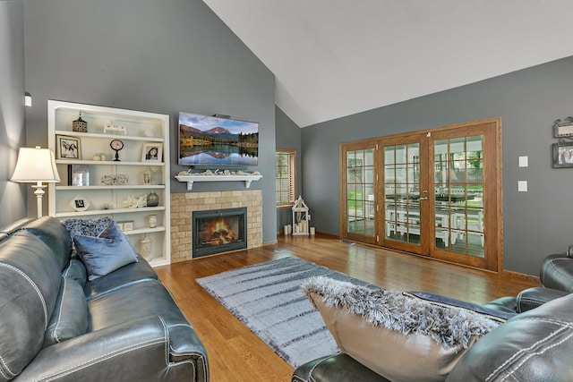 living room with high vaulted ceiling, wood finished floors, plenty of natural light, and a fireplace