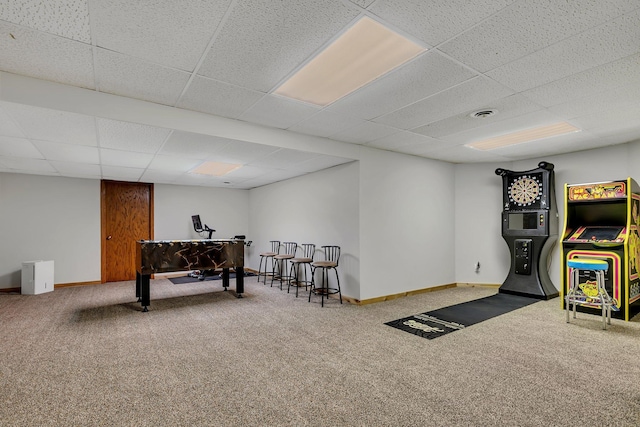recreation room with carpet, a drop ceiling, and baseboards