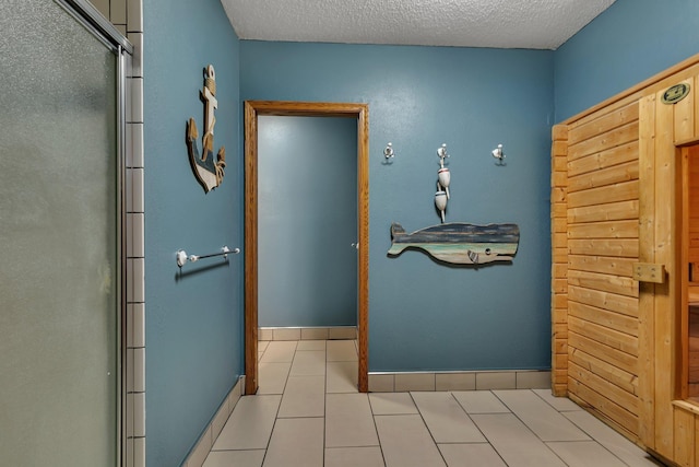 hall featuring a textured ceiling and tile patterned floors