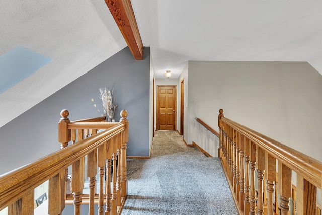 hallway featuring an upstairs landing, carpet, and baseboards