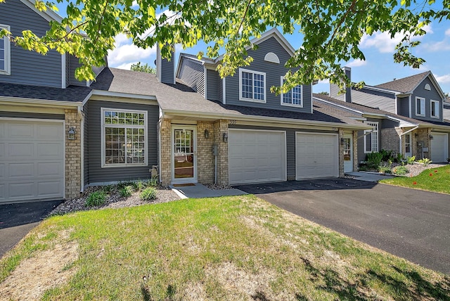 view of front of home with driveway, a front lawn, and an attached garage