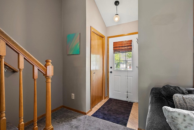 entryway featuring carpet floors, stairway, lofted ceiling, and baseboards