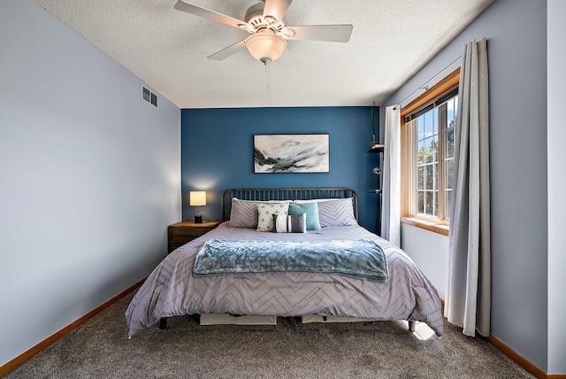 bedroom with carpet, a textured ceiling, baseboards, and a ceiling fan