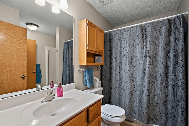 bathroom with a textured ceiling, toilet, vanity, and curtained shower