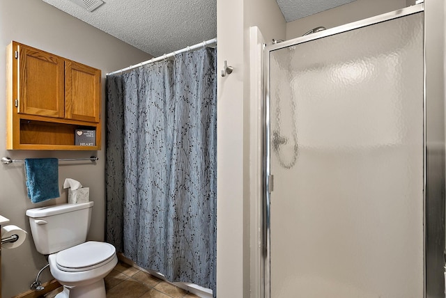 full bath with a shower stall, a textured ceiling, tile patterned floors, and toilet