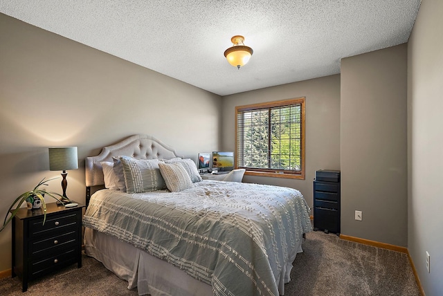 bedroom featuring dark colored carpet, baseboards, and a textured ceiling