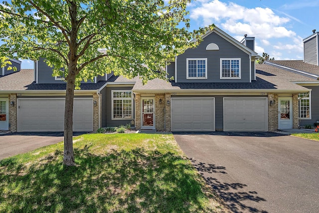 view of front of property with asphalt driveway, a garage, and brick siding