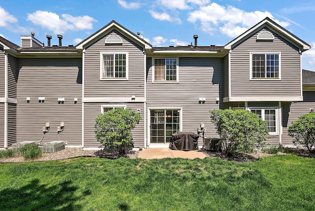 rear view of property featuring a yard and central AC unit