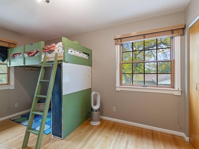 110116 Arboretum Way, Chaska, MN 55318 - unfurnished bedroom with wood finished floors, multiple windows, and baseboards
