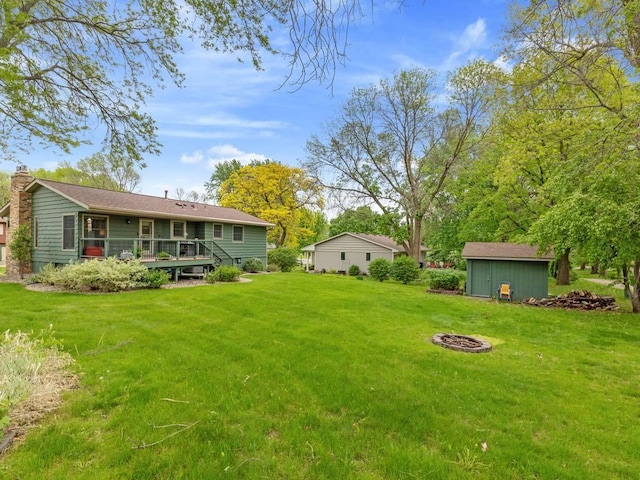 110116 Arboretum Way, Chaska, MN 55318 - view of grassy yard with a wooden deck and an outdoor fire pit