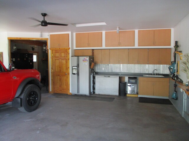 8300 263rd St, Saint Cloud, MN 56301 - garage with white refrigerator with ice dispenser, a sink, and ceiling fan