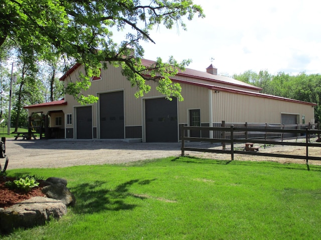 8300 263rd St, Saint Cloud, MN 56301 - back of house featuring a garage, driveway, an outdoor structure, and an exterior structure
