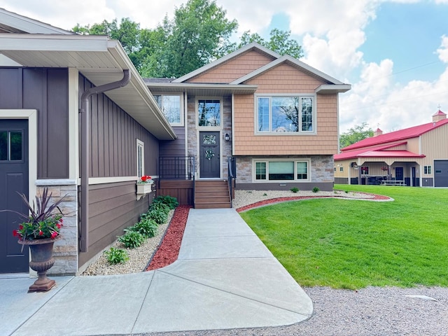 8300 263rd St, Saint Cloud, MN 56301 - view of front facade featuring a front yard, stone siding, and board and batten siding