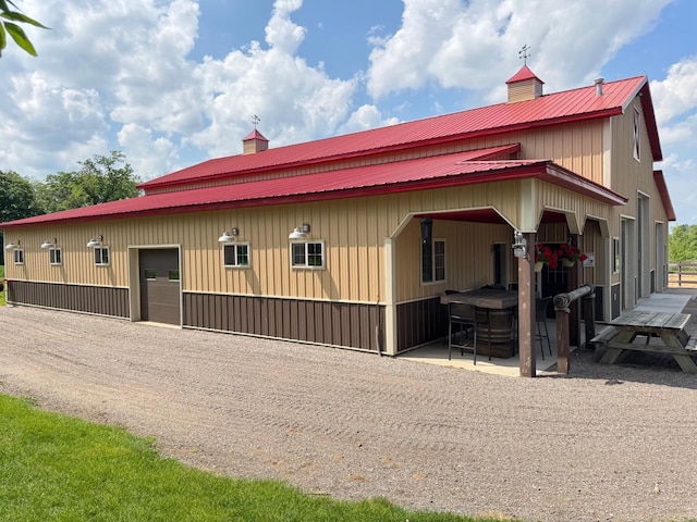 8300 263rd St, Saint Cloud, MN 56301 - view of side of property with metal roof, a patio, and a chimney