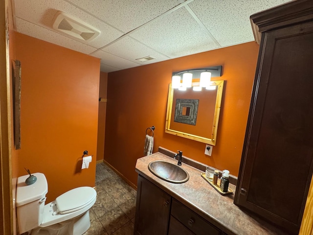 8300 263rd St, Saint Cloud, MN 56301 - bathroom featuring toilet, vanity, a paneled ceiling, and tile patterned flooring