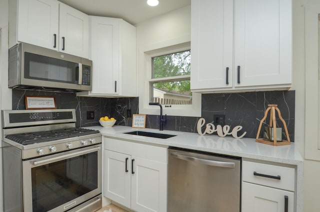 1459 Maywood St, Saint Paul, MN 55117 - kitchen featuring appliances with stainless steel finishes, a sink, white cabinets, and backsplash