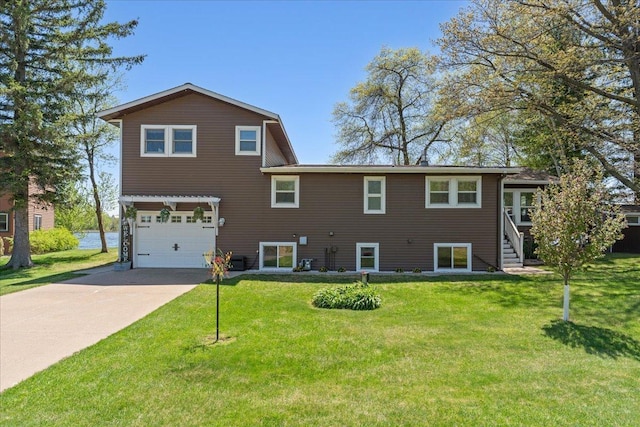 rear view of property featuring a garage, driveway, and a yard