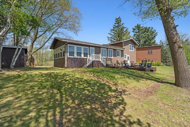 rear view of property featuring a lawn and an outdoor structure