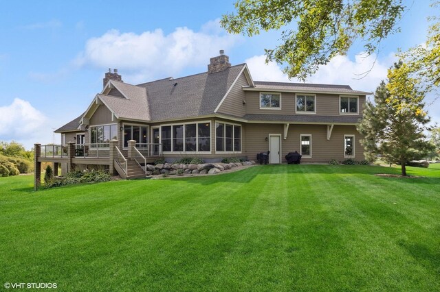 23380 127th St, Glenwood, MN 56334 - back of house featuring a sunroom, a lawn, a wooden deck, and a chimney