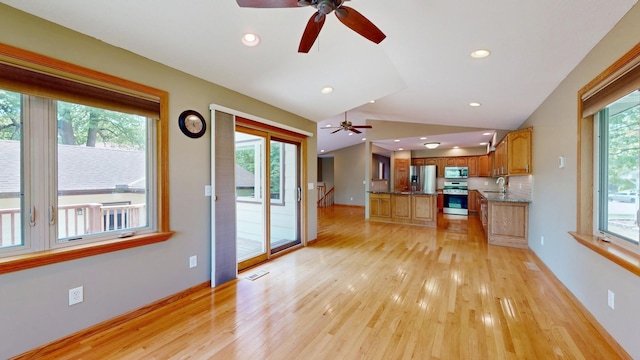 13073 Eldorado St NE, Blaine, MN 55449 - kitchen featuring appliances with stainless steel finishes, ceiling fan, light wood-style floors, vaulted ceiling, and brown cabinetry