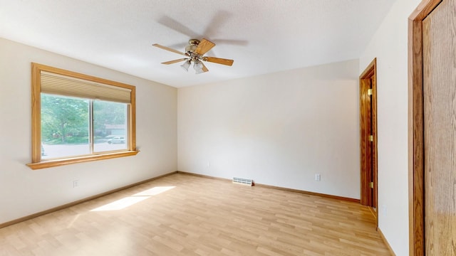 13073 Eldorado St NE, Blaine, MN 55449 - empty room with light wood-style floors, a ceiling fan, and baseboards
