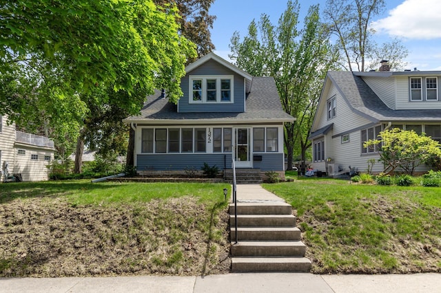 view of front facade featuring a sunroom and a front yard