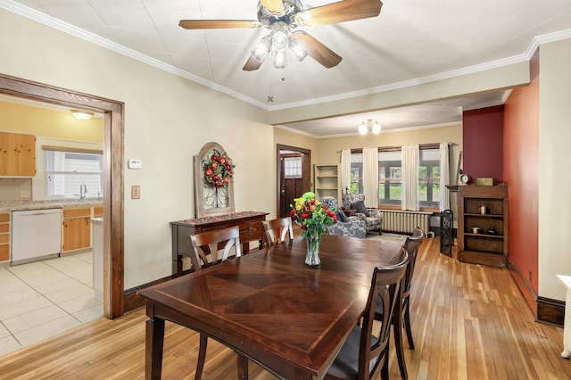 dining space with light wood-style floors, ceiling fan, baseboards, and ornamental molding