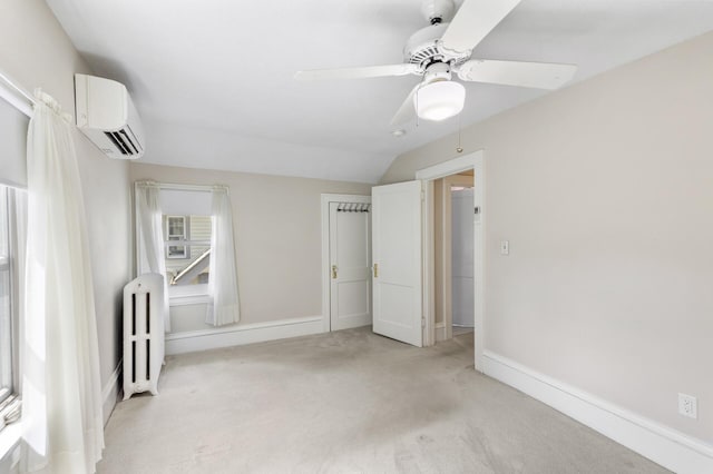 unfurnished bedroom with radiator, an AC wall unit, light carpet, vaulted ceiling, and baseboards