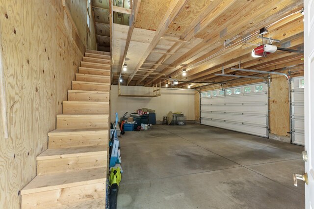 garage with a garage door opener and wooden walls