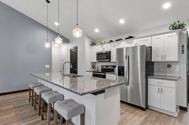 508 14th St NW, Waseca, MN 56093 - kitchen with stainless steel appliances, a sink, a breakfast bar area, light wood-style floors, and recessed lighting