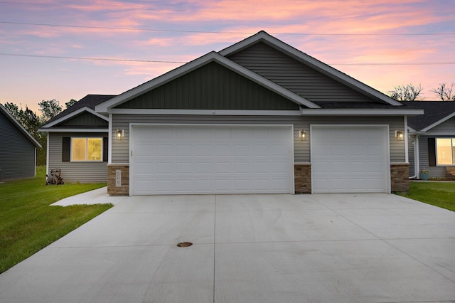 508 14th St NW, Waseca, MN 56093 - view of front of property featuring concrete driveway, stone siding, a garage, and a front lawn